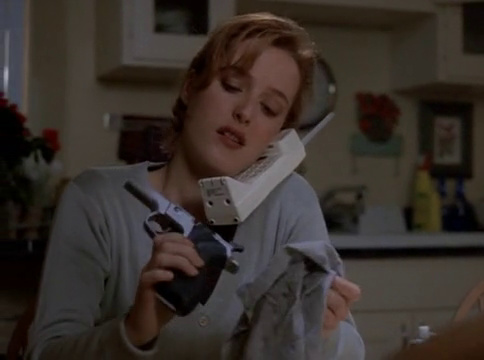 Scully on the phone, cleaning her gun